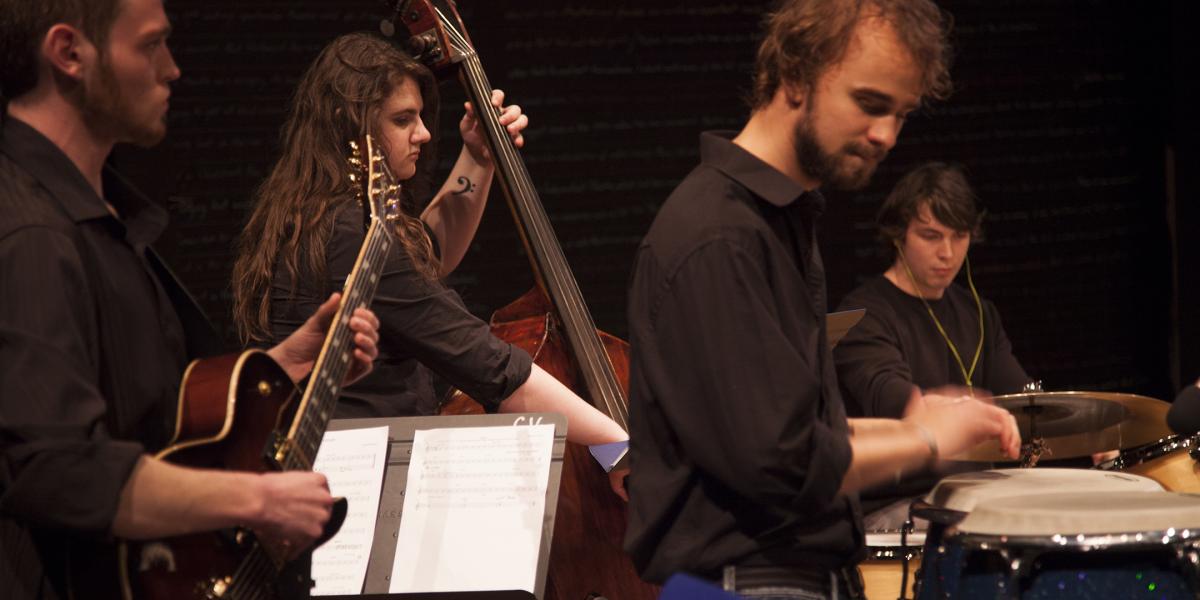 young men and women playing drums, guitar and double bass