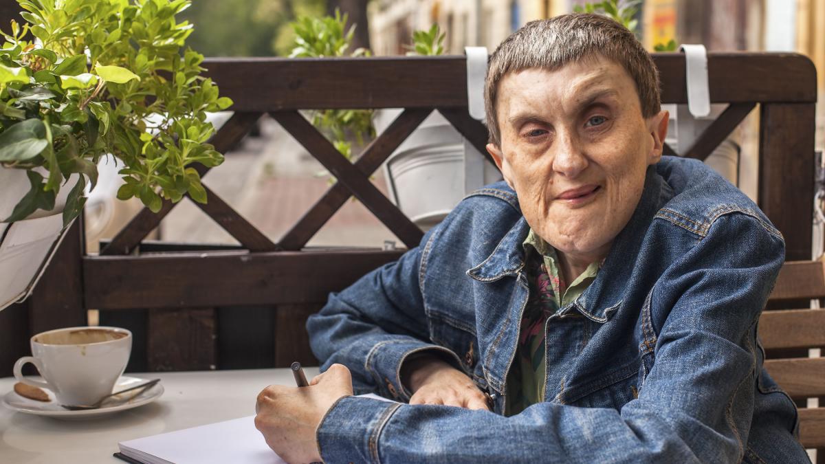 photo of man at table writing