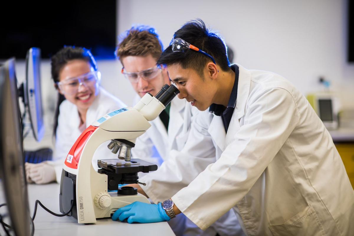 student looking through a microscope