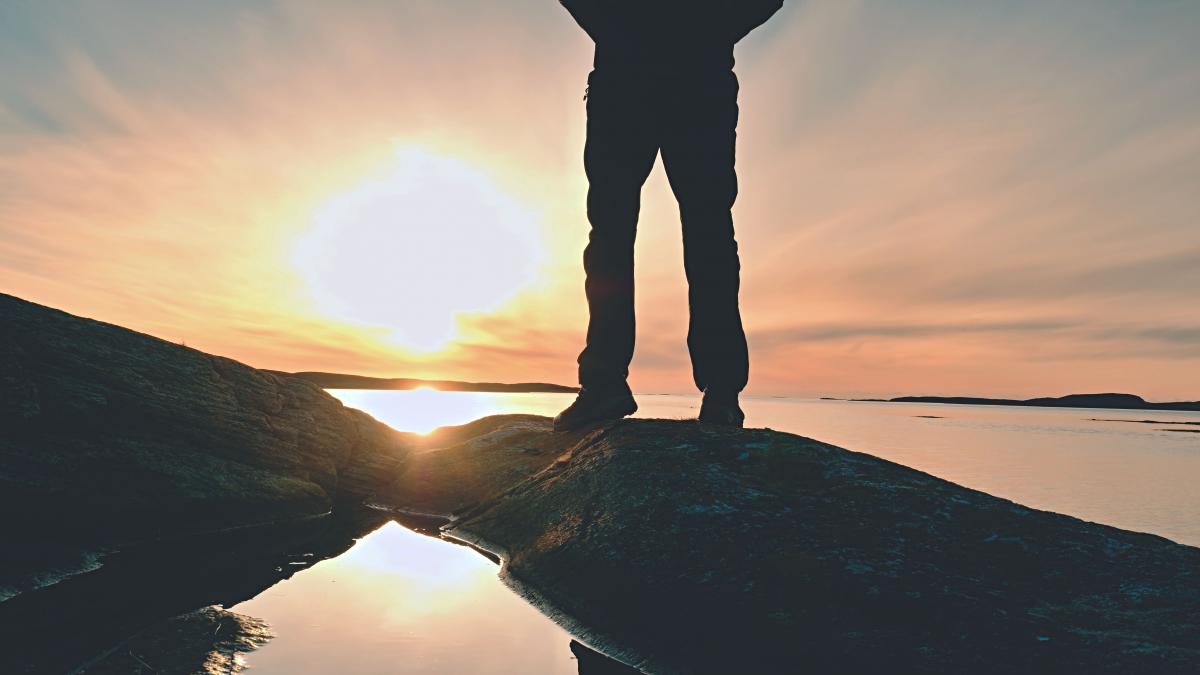 photo of a man overlooking the water at sunset