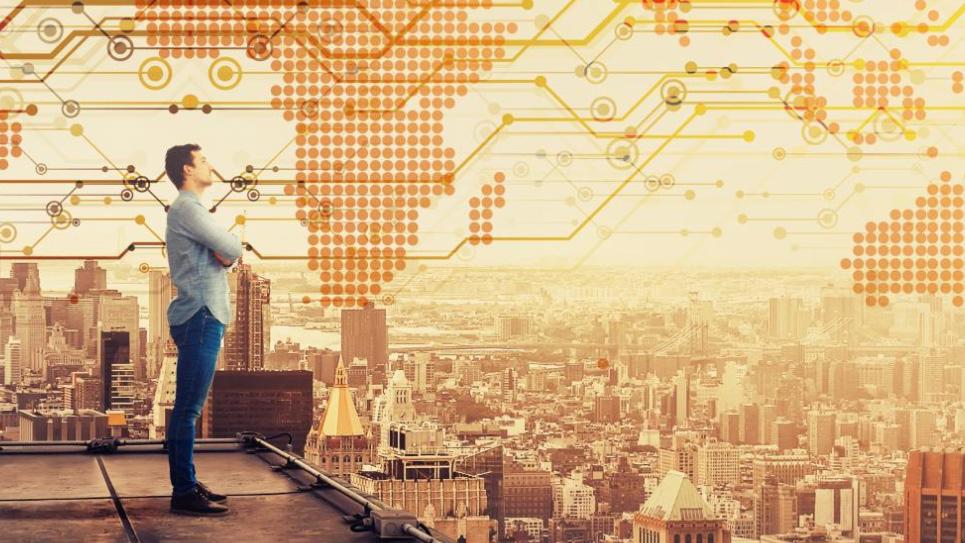 photo montage of man standing on builing looking out over a city