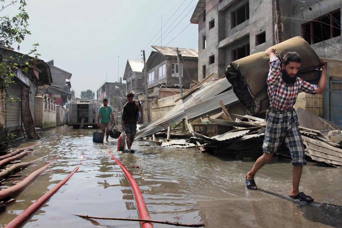 Crises, flood, man walking with supplies
