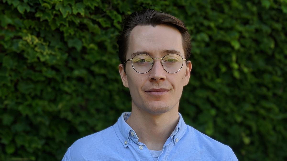 photo of a young man wearing a blue shirt and glasses